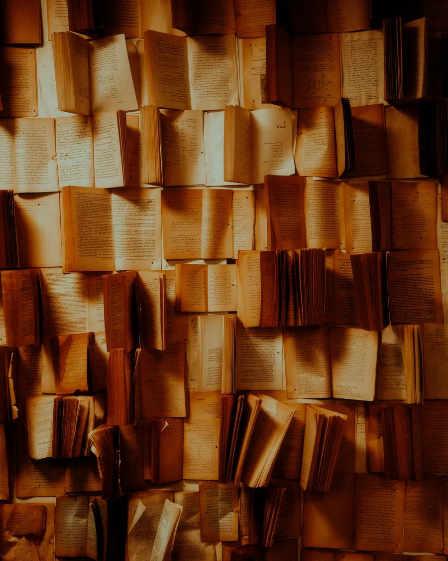 Des livres ouverts alignés, aux pages éclairées d'une lumière dorée