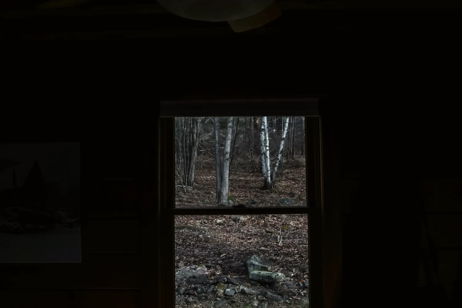 La fenêtre éclairée d'une pièce sombre aux murs de briques