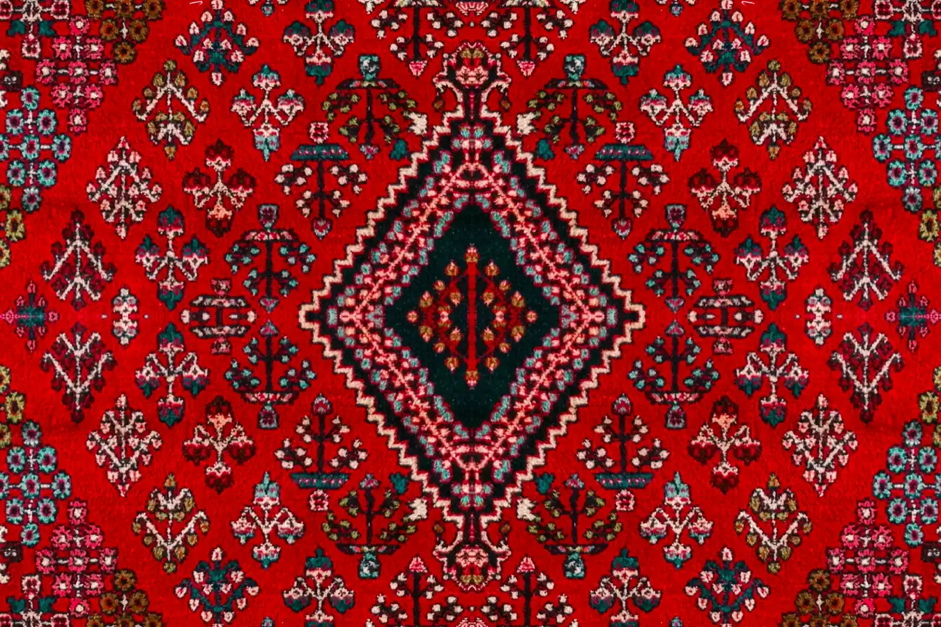 Un tapis persan rouge aux motifs géométriques, vu de dessus